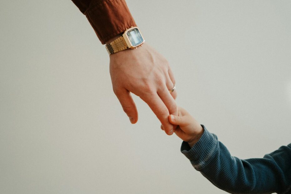 Adult hand holding a child hand, representing a guardian ad litem in a Virginia custody case