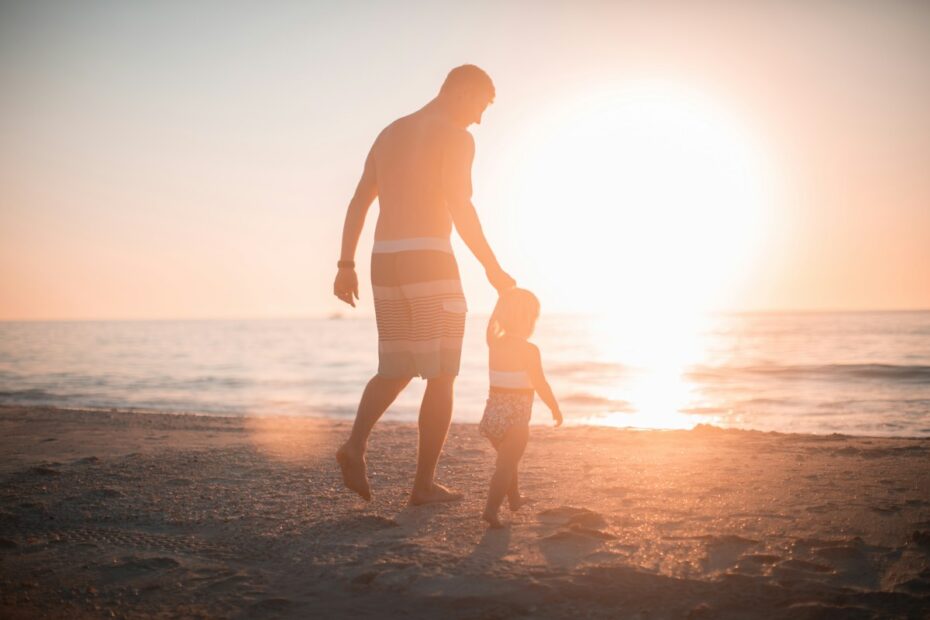 Father and toddler walking on a beach at sunset, representing parental fitness in Virginia custody cases